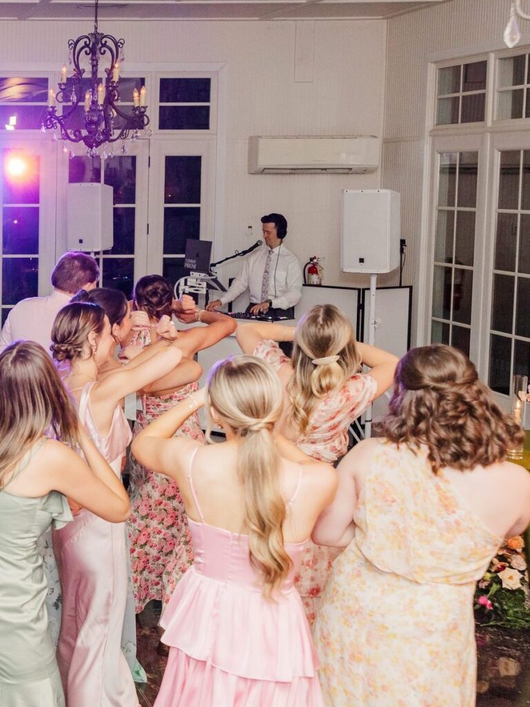 DJ Tommy Pirone at the DJ booth as wedding guests dance The Wobble at Little River Farms in Alpharetta GA