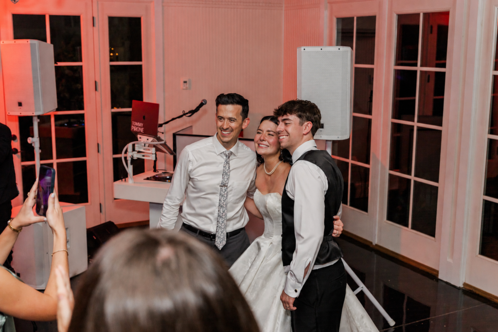 DJ Tommy Pirone posing with the bride and groom by the DJ booth at their Little River Farms wedding in Alpharetta GA
