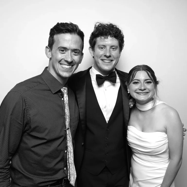 Black and white photo booth picture of three wedding guests in formal attire against a white backdrop — Pirone Entertainment