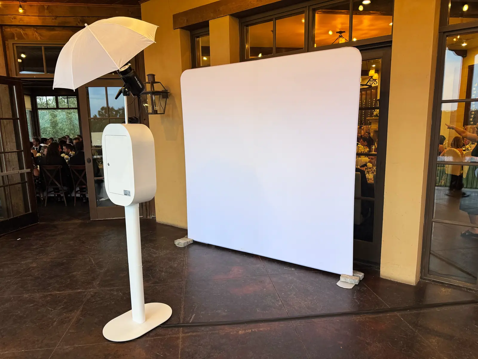White photo booth with flash umbrella beside a white fabric backdrop outside the reception room at Montaluce Winery & Vineyards — Pirone Entertainment